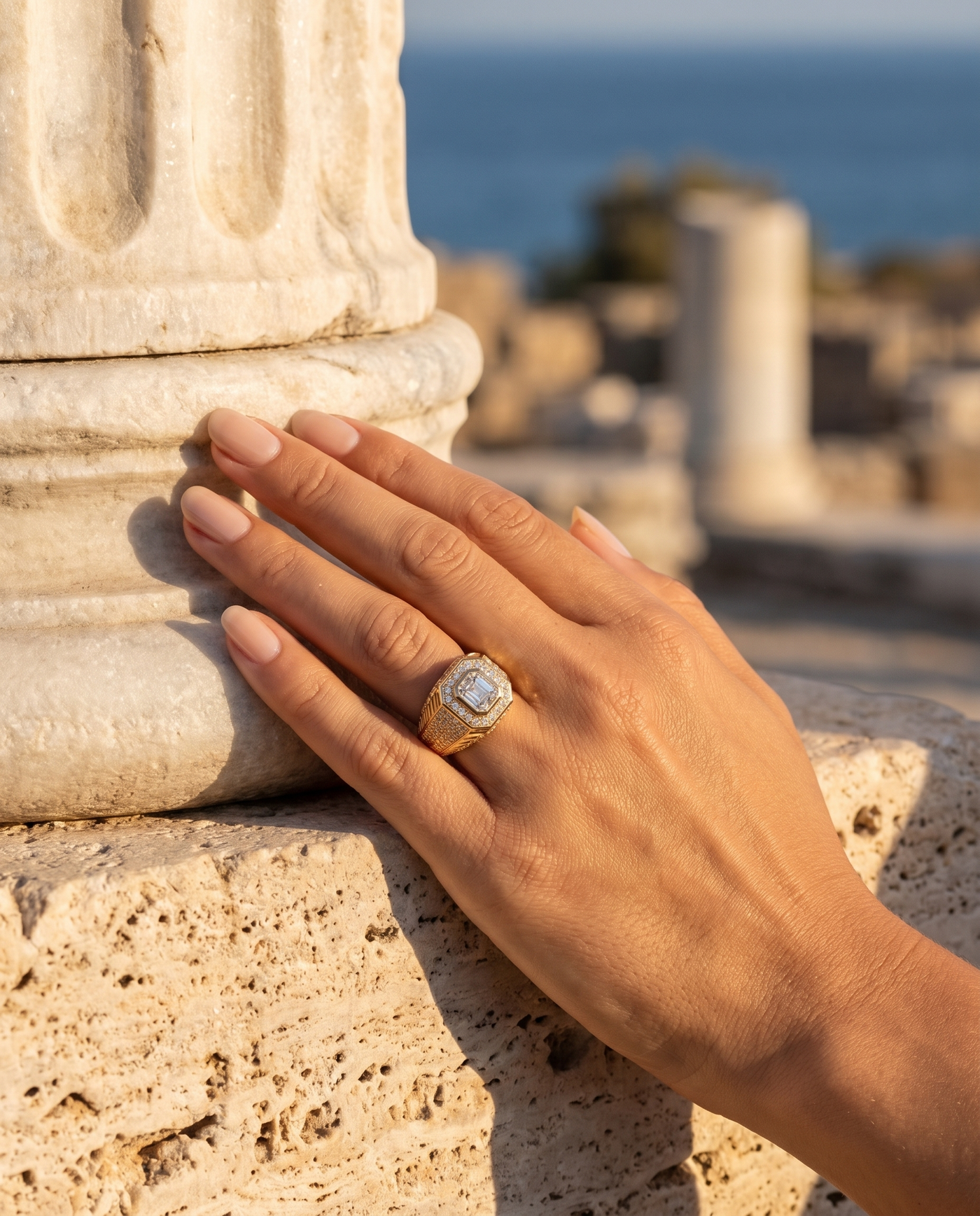 The Imperium Ring worn on a hand by an ancient column overlooking the sea