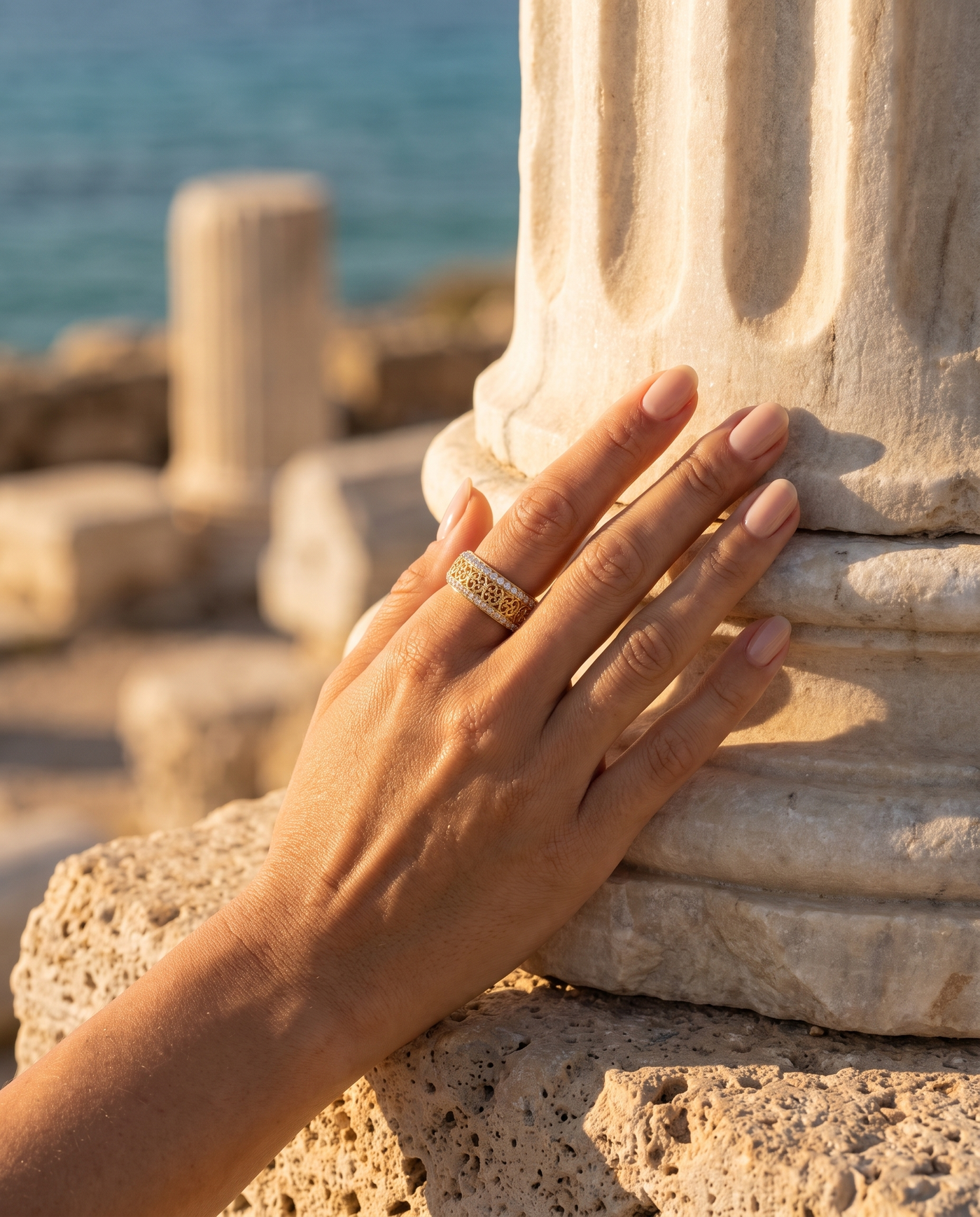 The Valencia Ring worn on a hand by an ancient column overlooking the sea