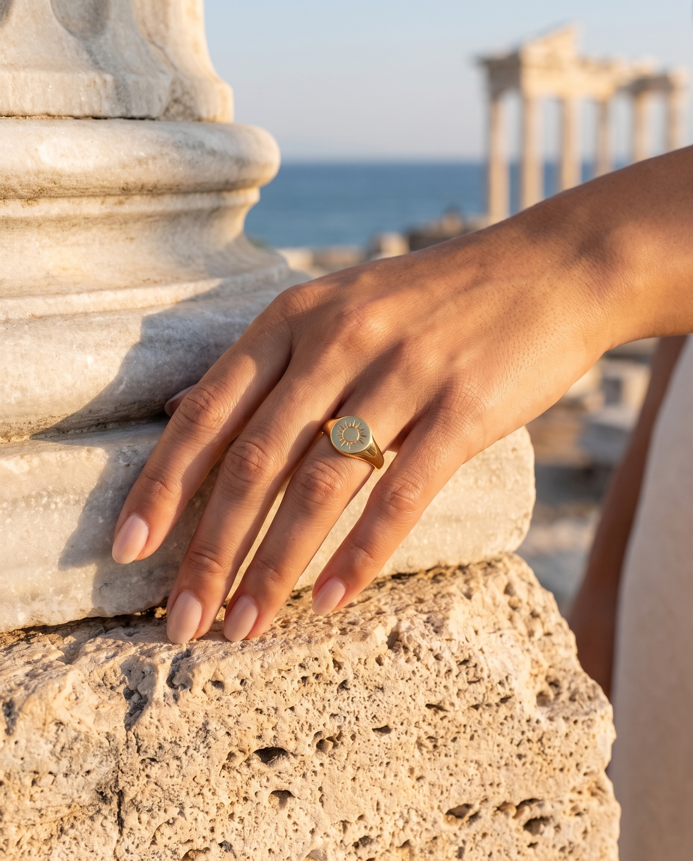 Solare Signet Ring worn on a hand by an ancient column overlooking the sea