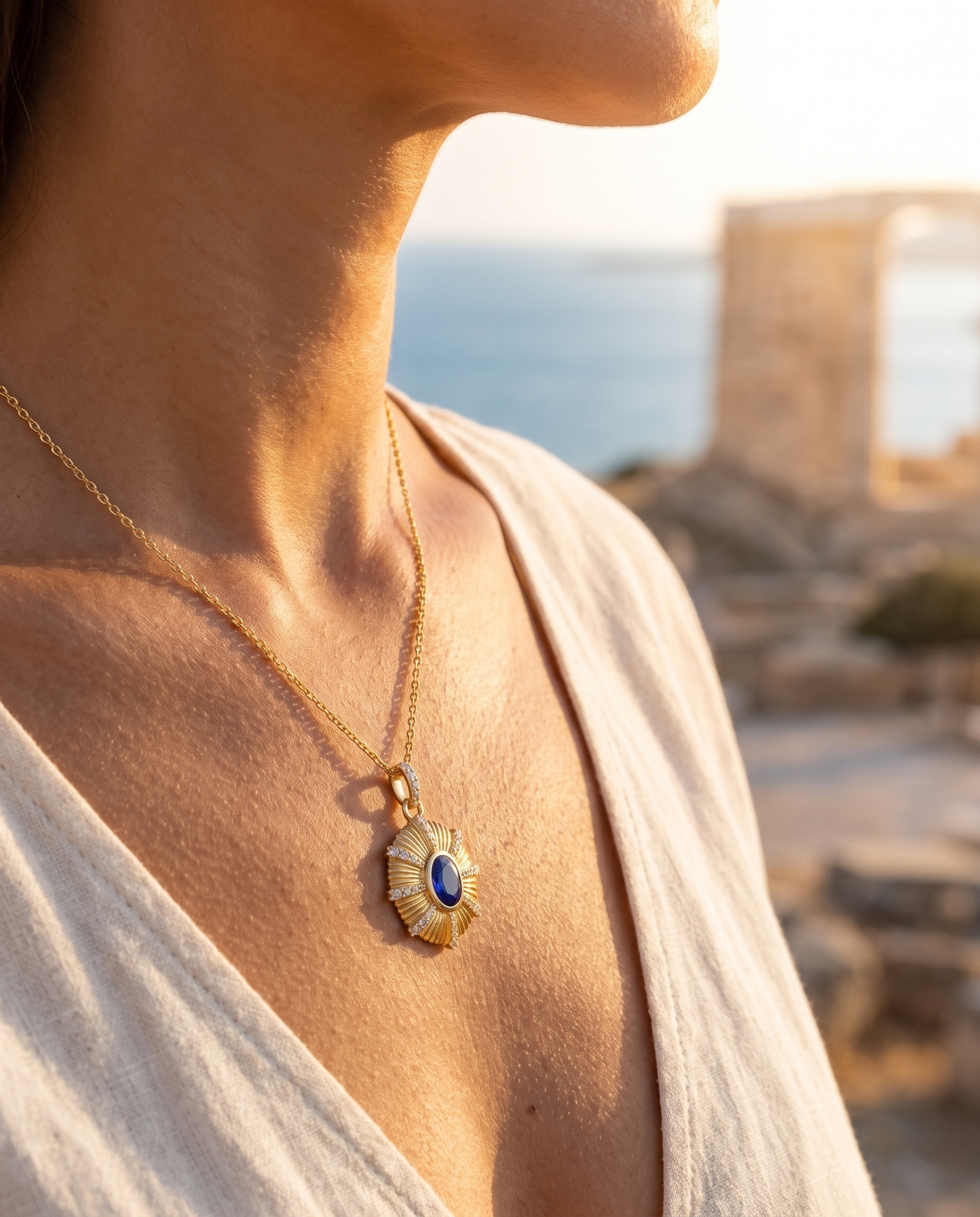 The Zenia Pendant worn at the decolletage overlooking the sea