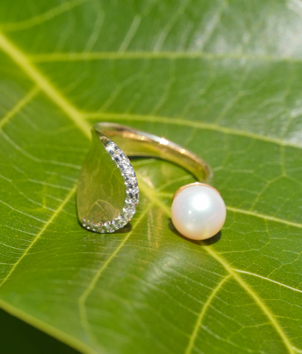 Gold open ring with a pearl and pavé diamond arc, showcasing modern elegance and timeless design