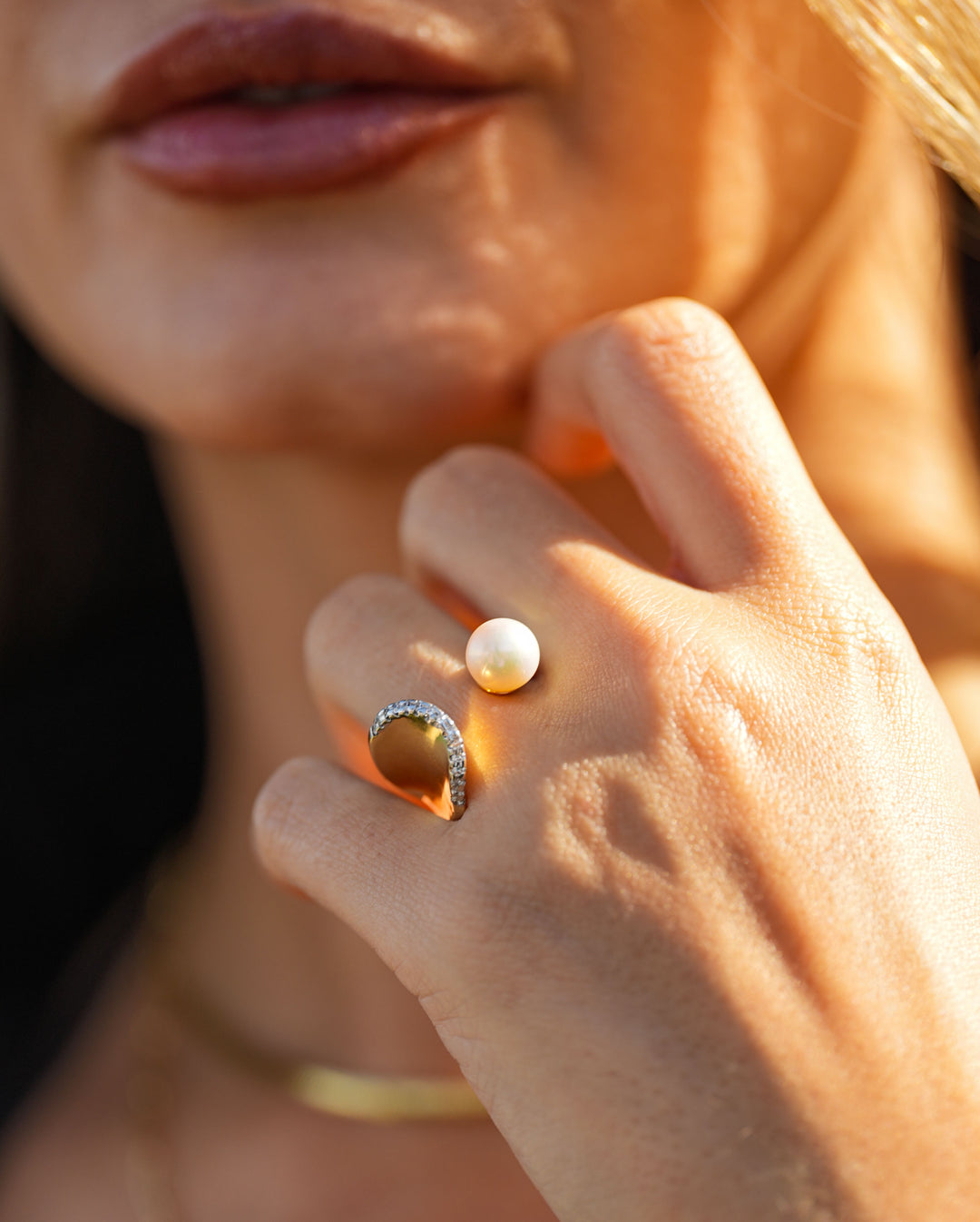 Gold open ring with a pearl and pavé diamond arc, showcasing modern elegance and timeless design
